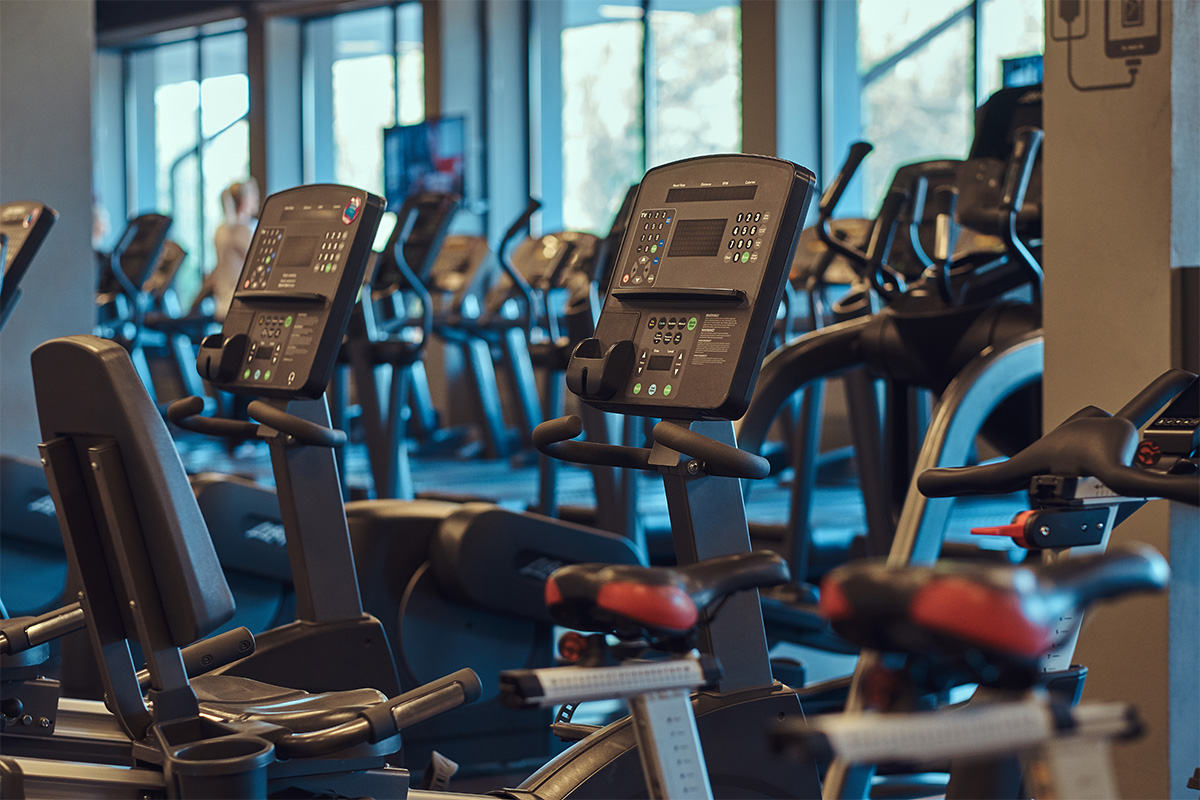 Commercial strength equipment arranged beside large gym windows